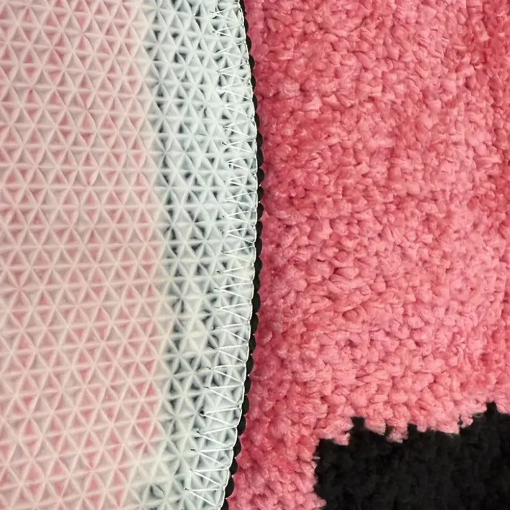 Tissu à motif géométrique rose et blanc avec une surface texturée.