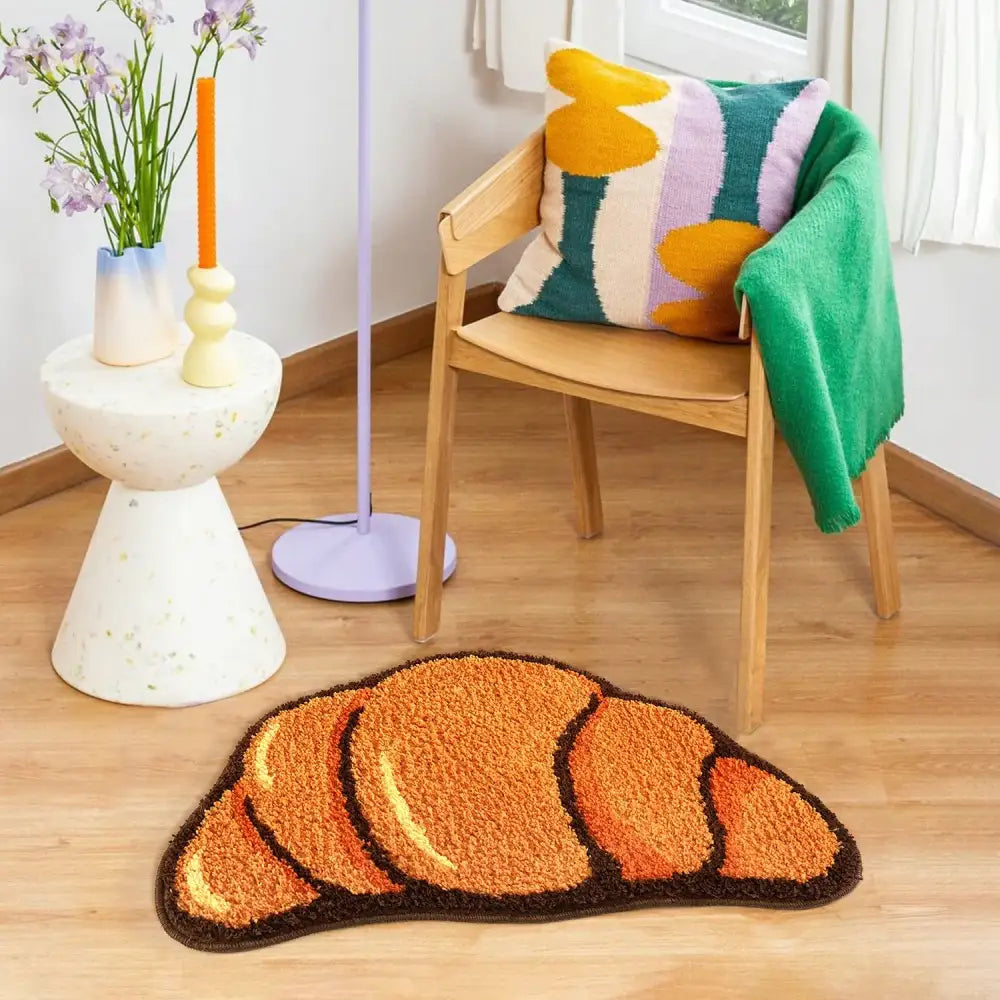 Tapis de bain en forme de croissant, tons orange et marron avec surface texturée, probablement fabriqué en matériau moelleux pour le confort.