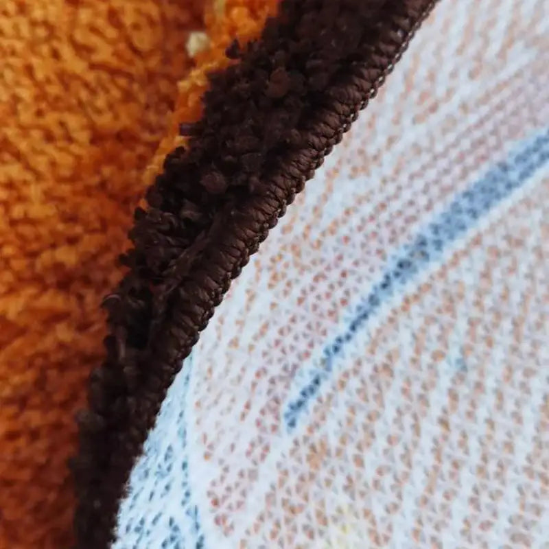 Couverture en polaire orange et bleue avec détail de fermeture éclair marron.