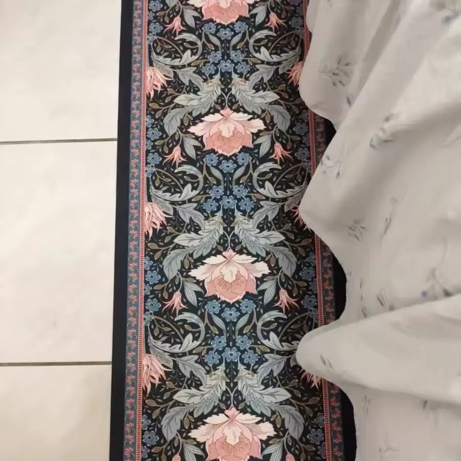 Tapis floral bleu marine avec des fleurs roses et blanches, design intricé.