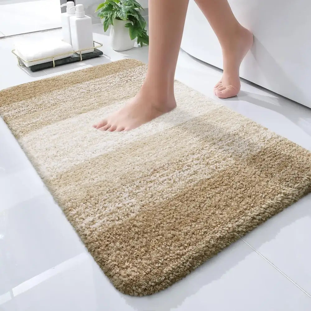 Tapis de bain en peluche rayé beige et crème avec des fibres douces et texturées.