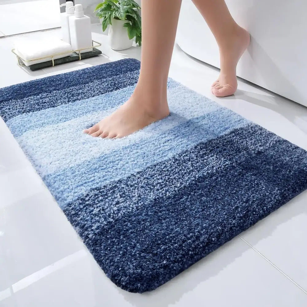 Un tapis de bain moelleux à dégradé bleu avec des fibres texturées douces dans des nuances variées allant du clair au foncé.