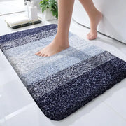 Un tapis de bain moelleux à dégradé bleu avec une surface texturée douce et des bords arrondis.