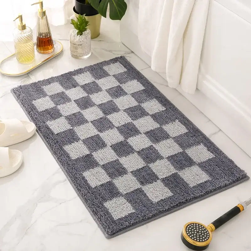 Tapis de bain à carreaux gris et blanc avec une pile texturée, probablement fabriqué en microfibre ou un matériau doux similaire.