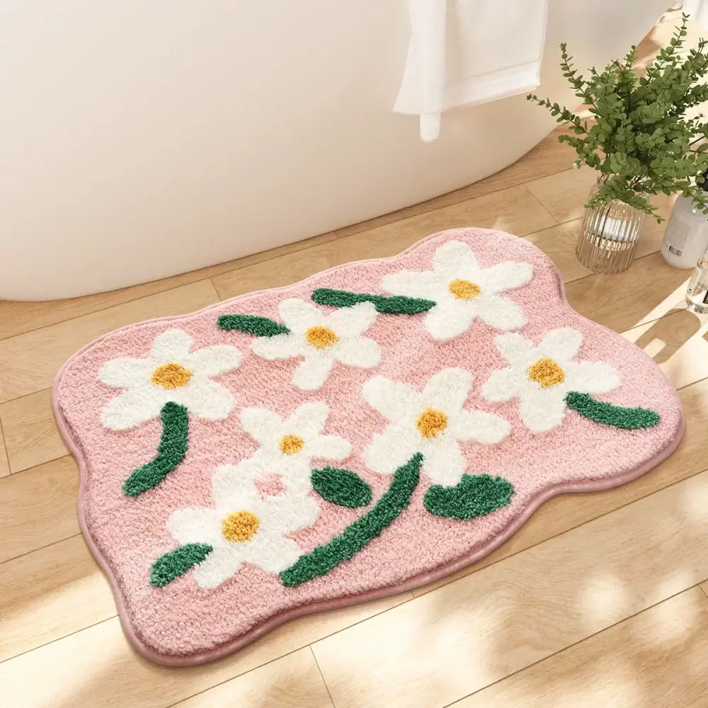 Tapis de bain floral rose avec des fleurs blanches et des feuilles vertes, fabriqué en microfibre douce.