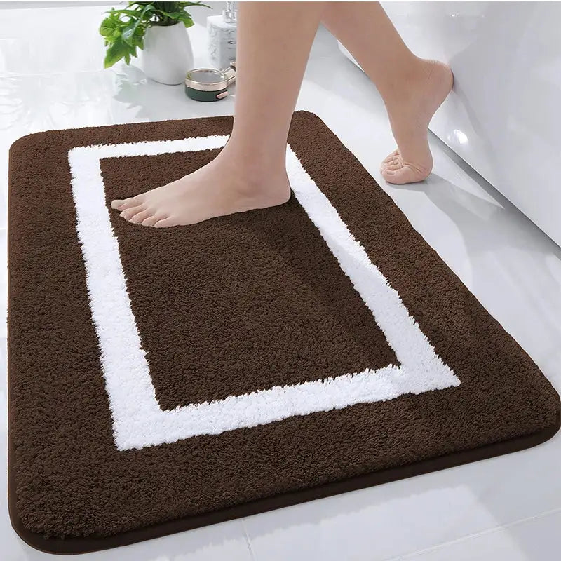 Tapis de bain marron et blanc avec un design rectangulaire, matériau doux pour le confort.