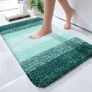 Un tapis de bain moelleux à dégradé vert avec une texture douce et duveteuse et une transition du menthe clair au teal profond.