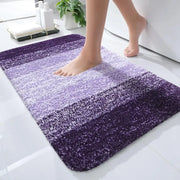 Un tapis de bain moelleux à dégradé violet avec une texture douce et duveteuse et un fondu subtil de clair à foncé.