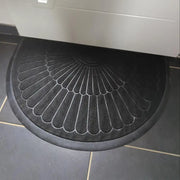 Tapis semi-circulaire noir avec un motif texturé en forme d’éventail.