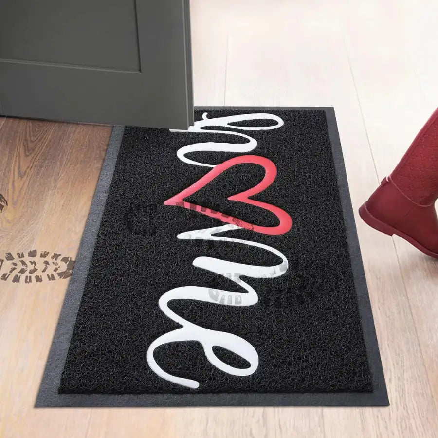 Paillasson en caoutchouc noir avec motif de cœur blanc et rouge, texte ’love’ en script cursive.