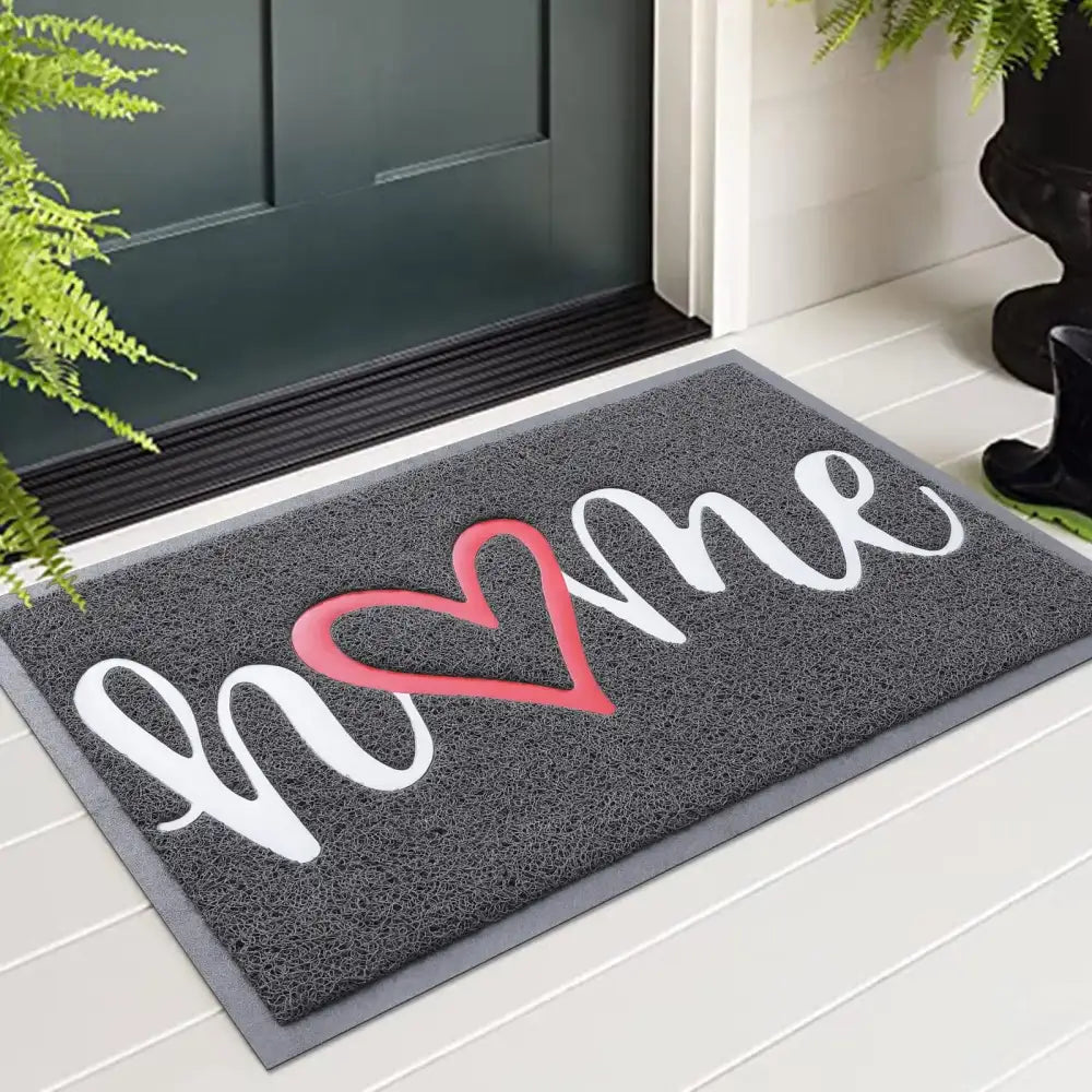 Paillasson ’home’ gris avec design de cœur rouge, dos en caoutchouc durable et surface texturée.