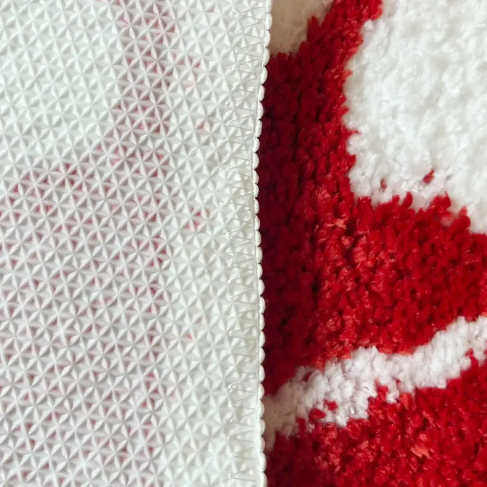 Tissu texturé rouge et blanc avec un motif géométrique, probablement un mélange de coton ou de polyester.