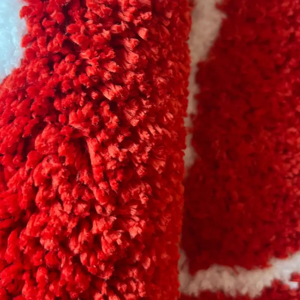 Couverture floue rouge avec doublure blanche et design de surface texturée.
