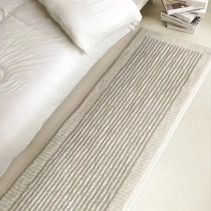 Tapis rayé beige avec tissage texturé, probablement fabriqué en laine ou en fibres synthétiques.