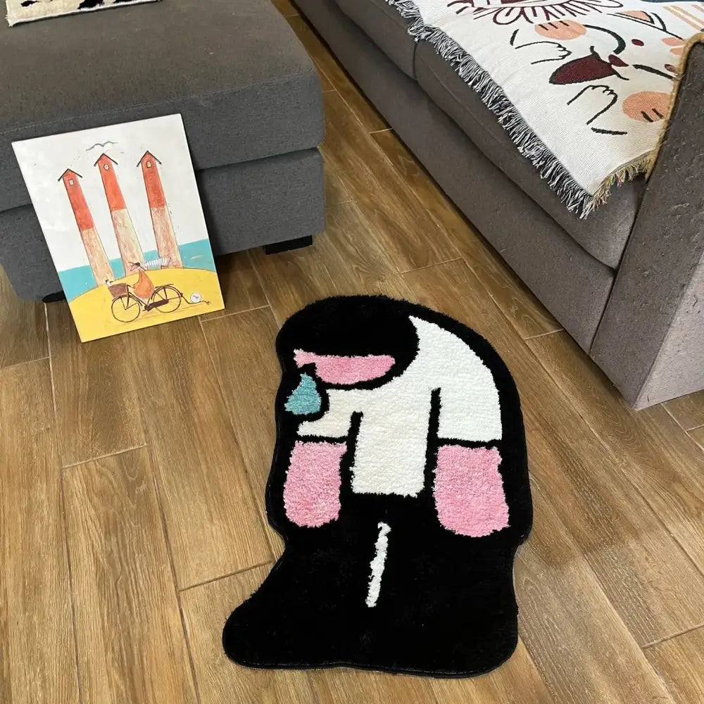 Tapis shaggy noir en forme de figure humaine stylisée avec des motifs abstraits rose, blanc et turquoise.