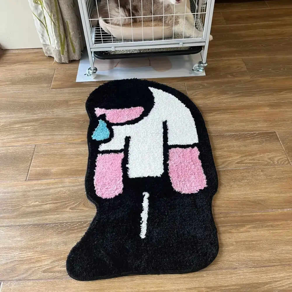 Tapis noir en peluche en forme de cornet de glace stylisé avec des sections roses et blanches et un détail de coulure bleu clair.