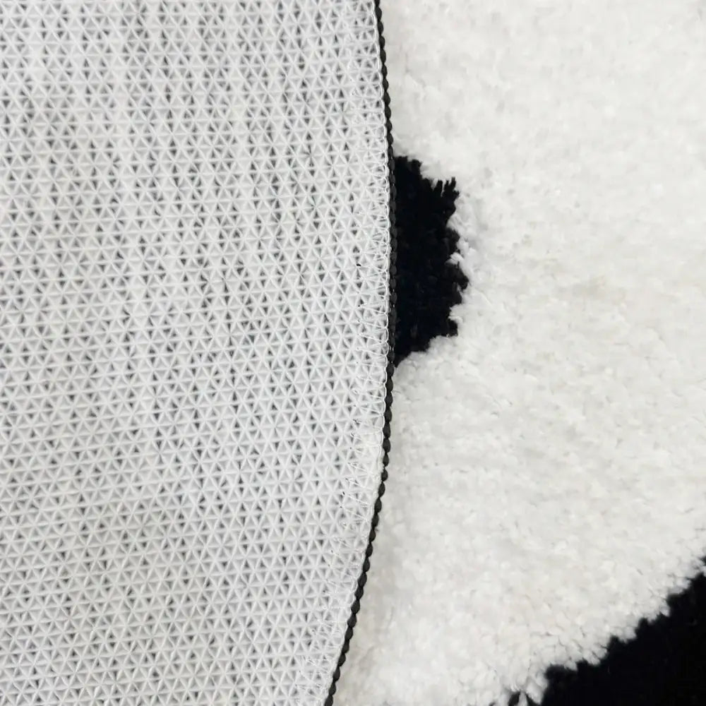 Tissu texturé blanc avec bordure en fourrure noire et bordure en chaîne.