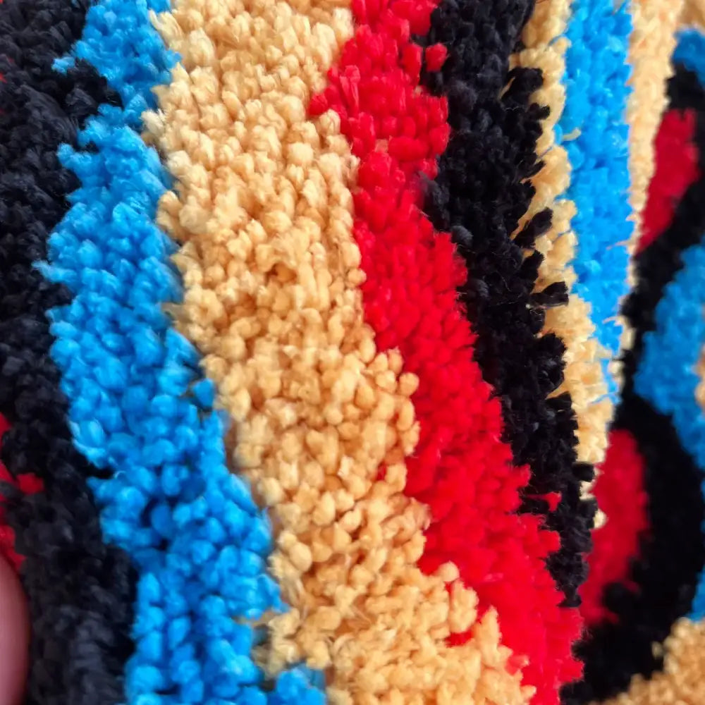 Tapis effet 3d avec serviette moelleuse à rayures bleu rouge noir et bande centrale beige créant une illusion d’optique