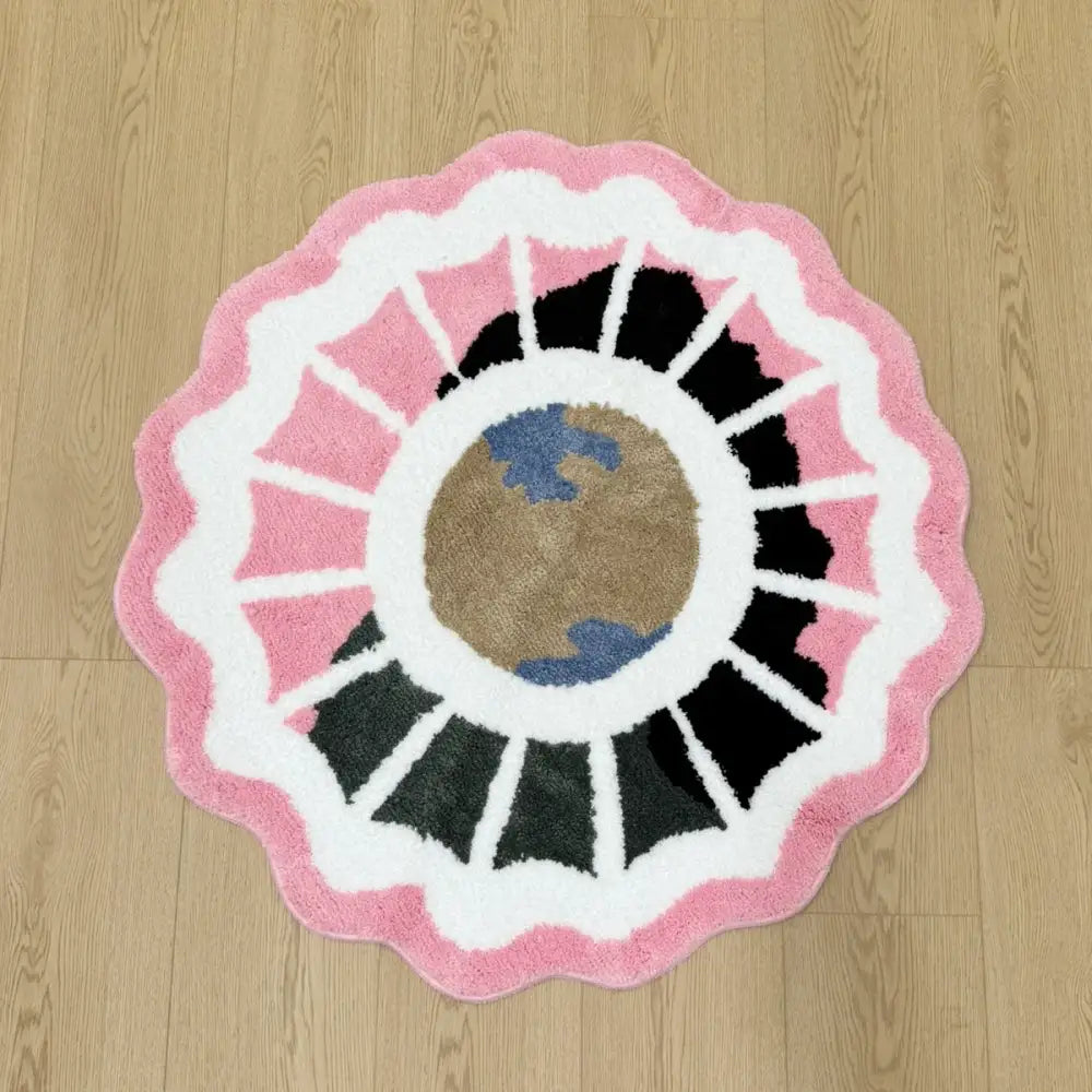Tapis de bain à bordure festonnée rose, blanc et noir avec un design central de la Terre.