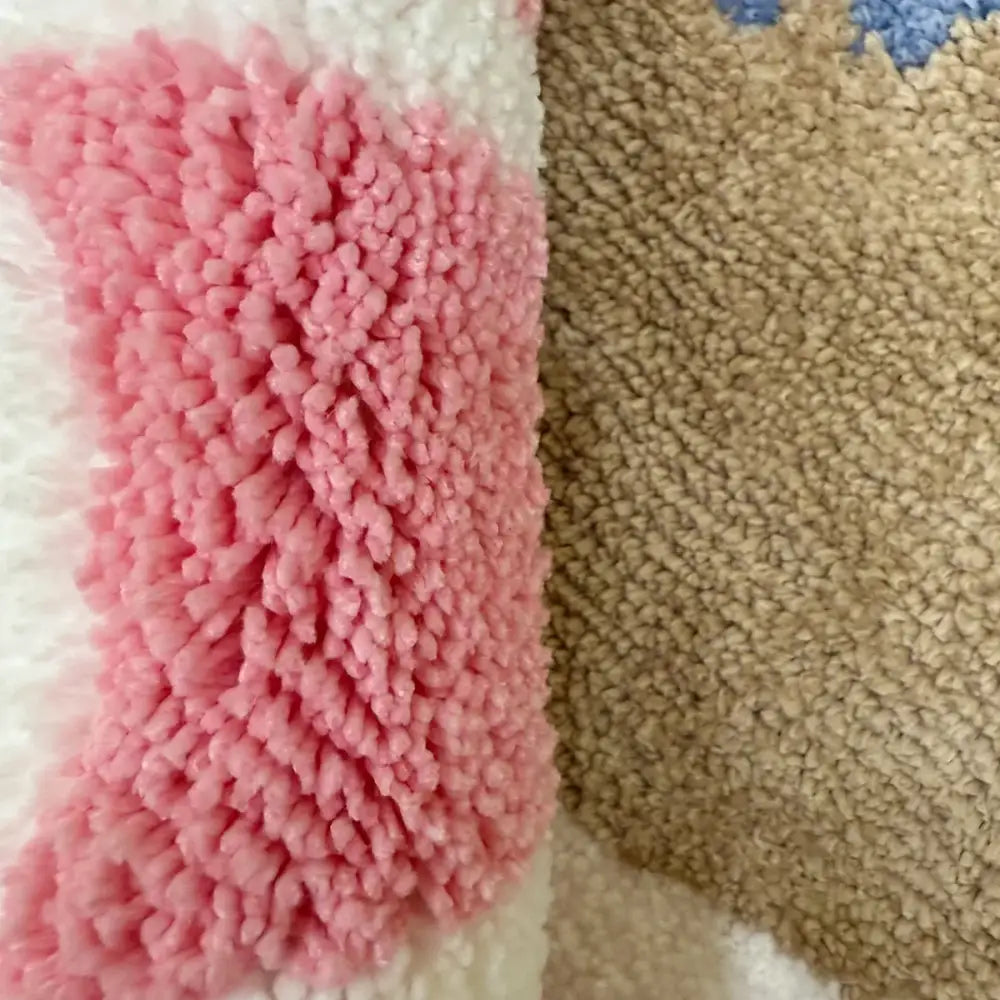 Tissu sherpa rose et blanc duveteux avec une surface douce et texturée.