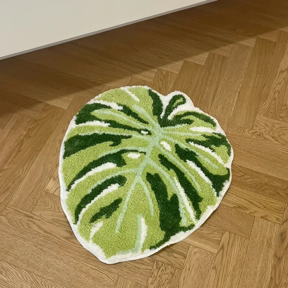 Tapis de bain en forme de feuille verte avec bordure blanche, fabriqué en matériau moelleux.