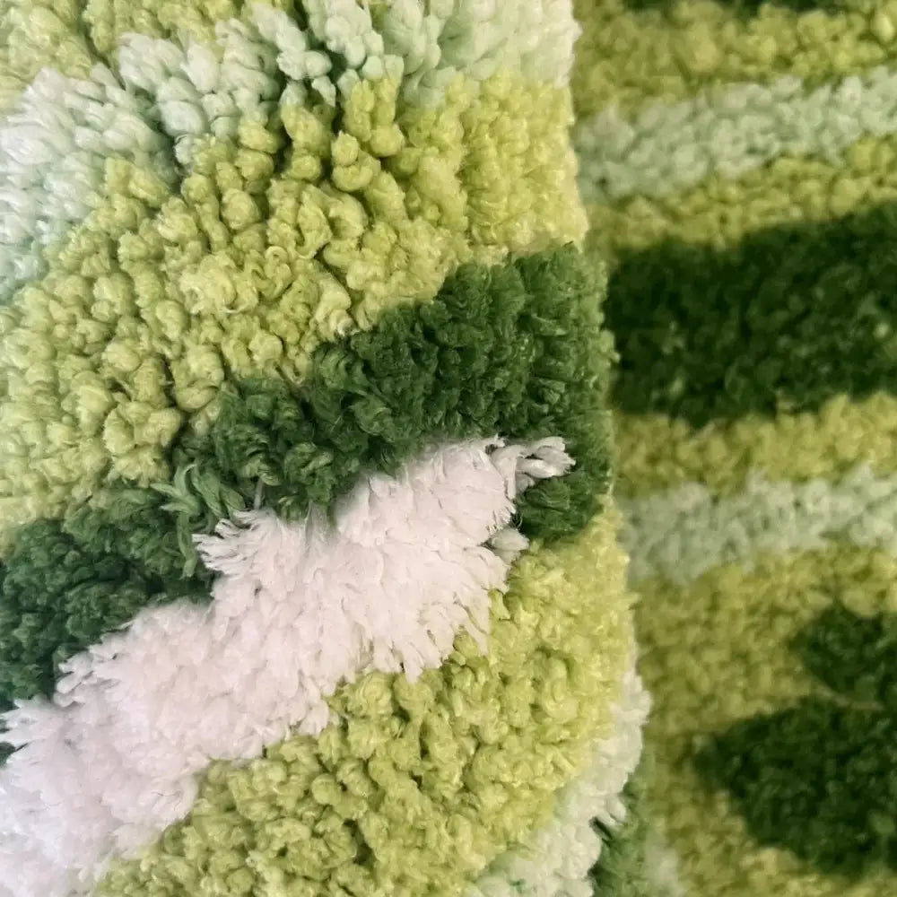 Tapis de bain texturé vert et blanc avec une moquette douce et moelleuse.