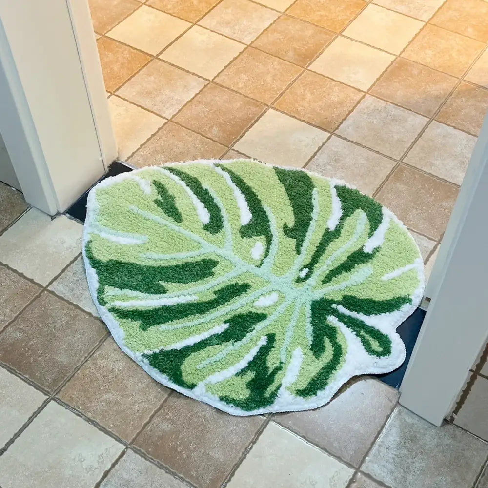 Tapis de bain en forme de feuille verte avec des veines blanches, fabriqué en matériau moelleux.