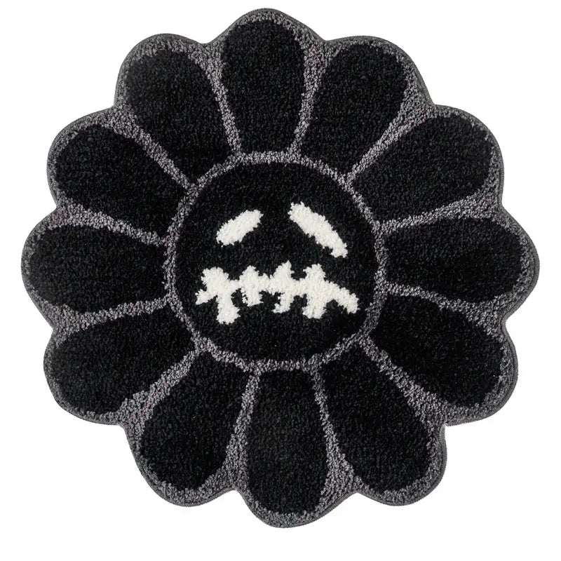 Tapis de bain noir et blanc à motif tournesol avec un design de visage effrayant, probablement fabriqué en matériau moelleux.