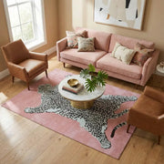 Canapé en velours rose avec accents dorés et coussins décoratifs à motif floral.