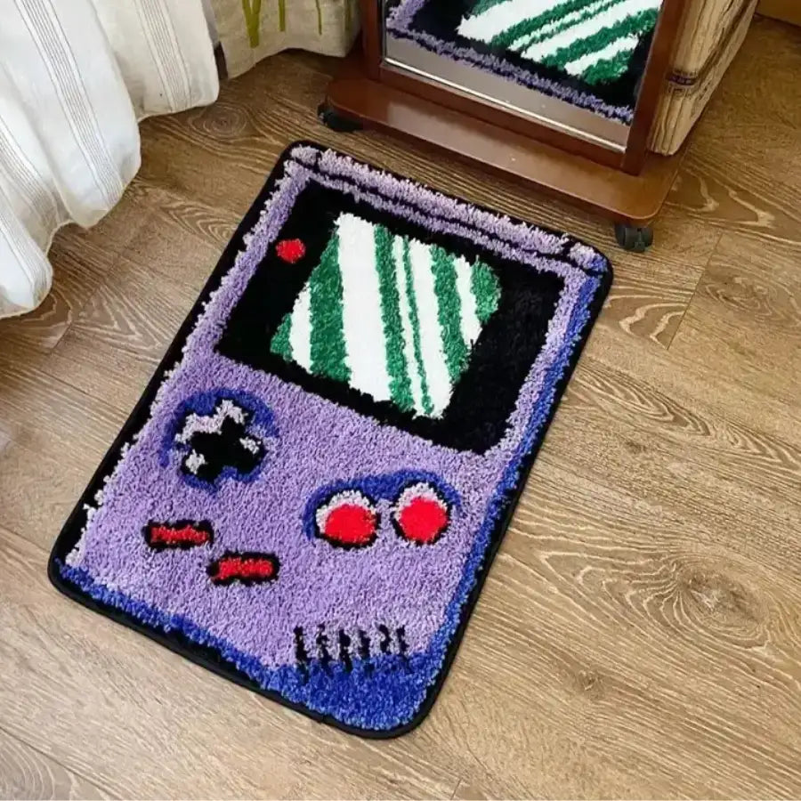 Tapis Game Boy violet avec écran vert et boutons rouges.