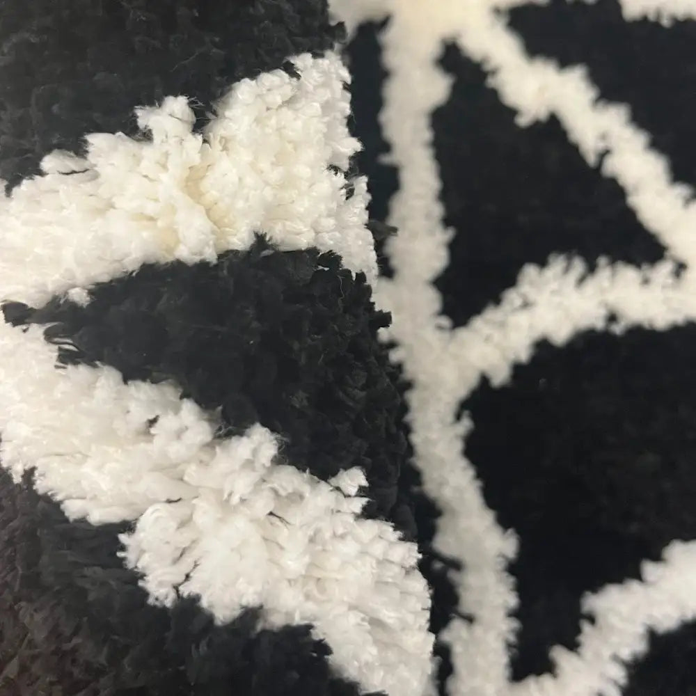 Tapis à motif géométrique noir et blanc avec velours texturé.