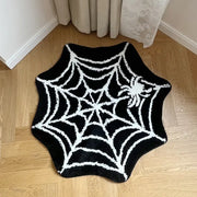 Tapis de bain à motif d’araignée en noir et blanc avec un design texturé, probablement fabriqué en matériau moelleux.