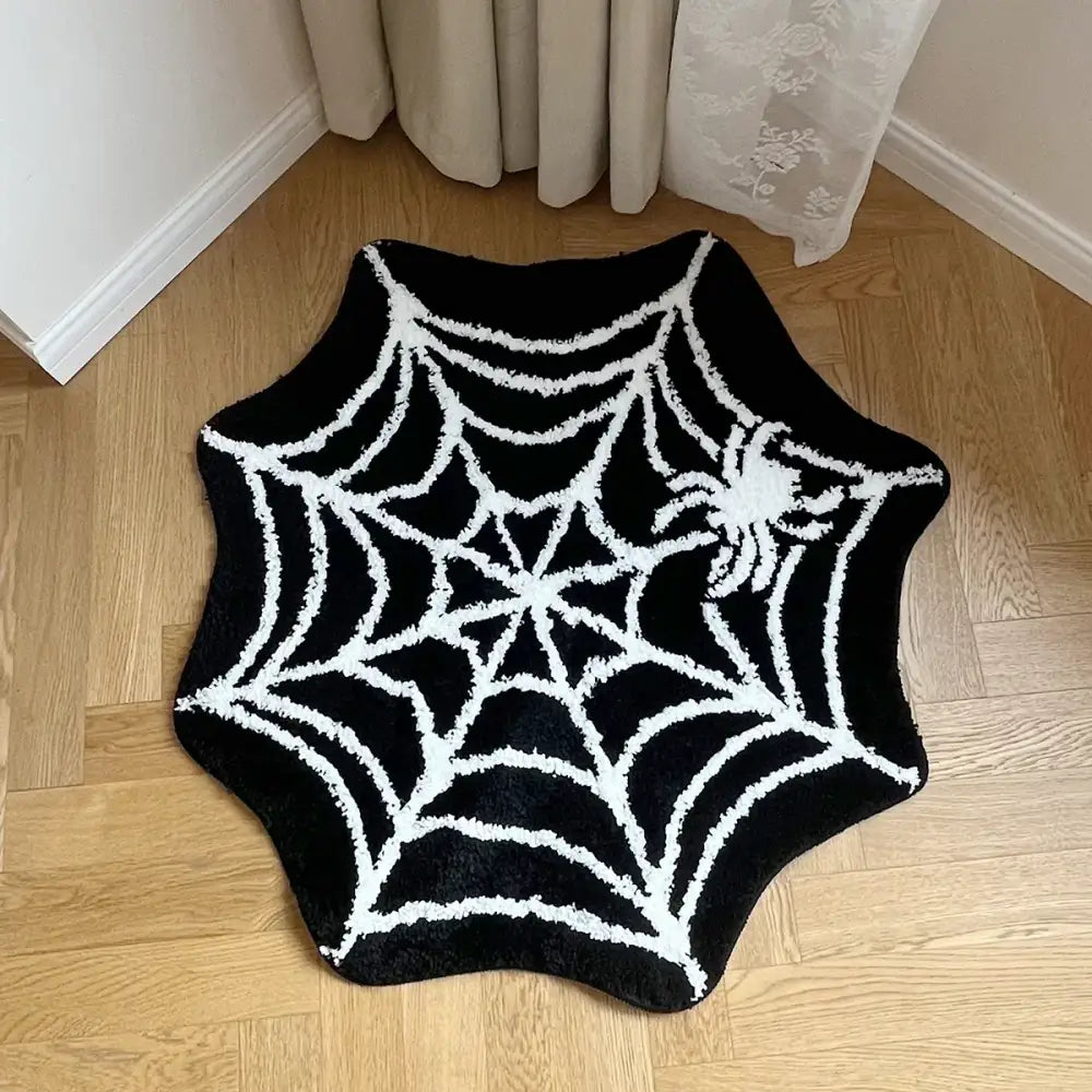 Tapis de bain à motif d’araignée en noir et blanc avec un design texturé, probablement fabriqué en matériau moelleux.