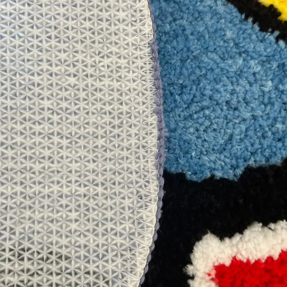 Vue du dos du tapis hot rod plush bleu noir et rouge avec un support en maille blanche