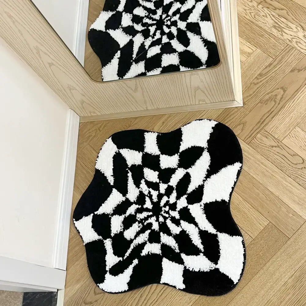 Tapis de bain spirale noir et blanc avec velours texturé.