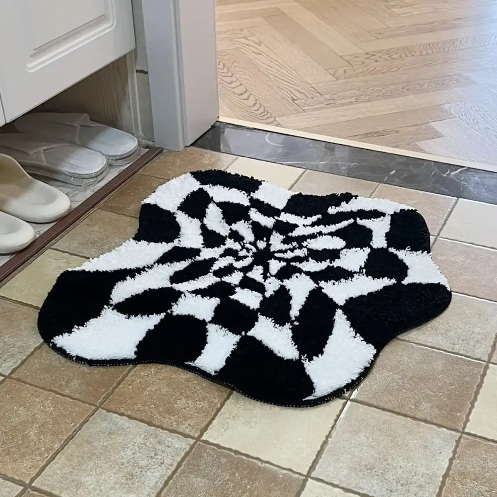 Tapis de bain spirale noir et blanc avec une pile texturée, probablement fabriqué en microfibre ou matériau similaire.