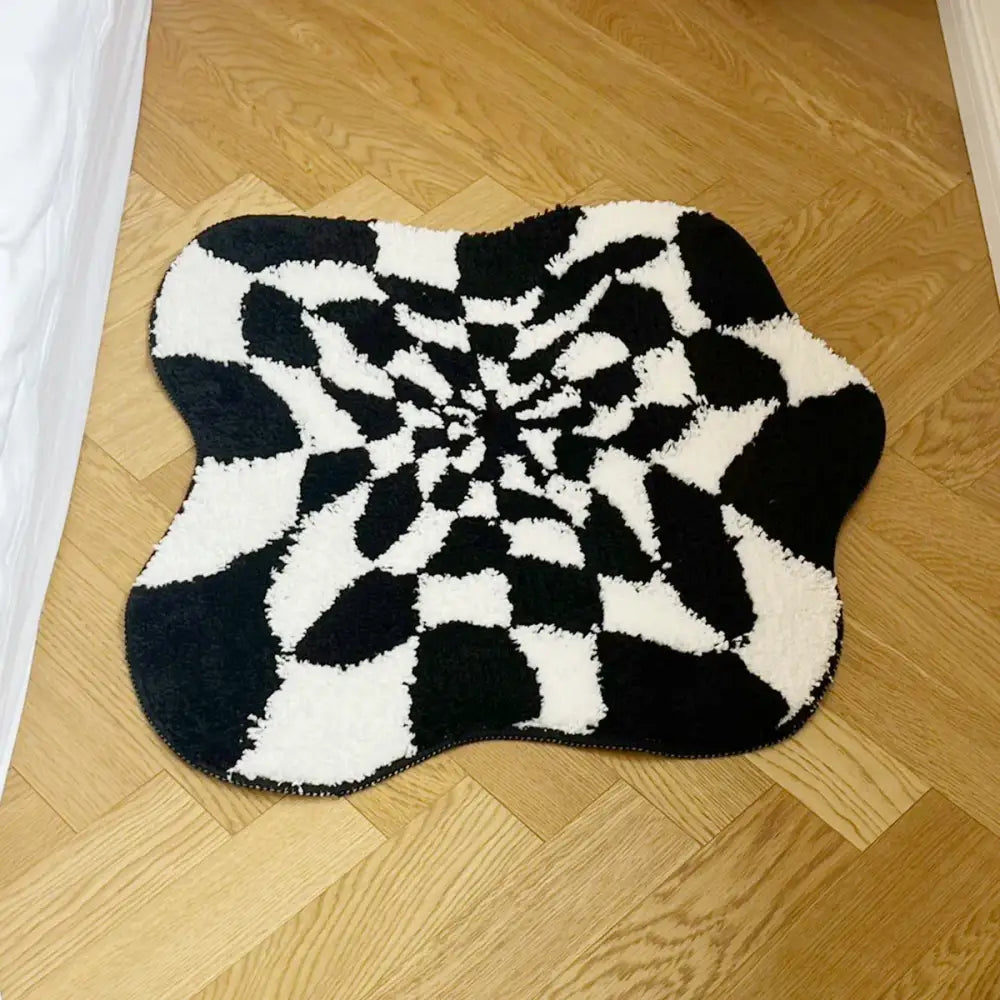 Tapis spiralé noir et blanc à velours texturé, probablement fabriqué en fibres synthétiques.