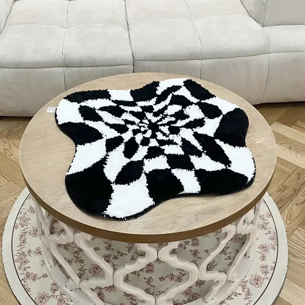 Tapis spiralé noir et blanc à velours texturé, design moderne.