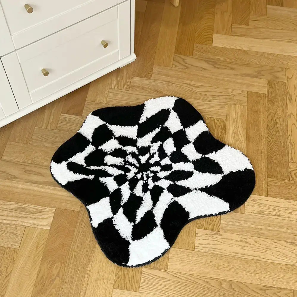 Tapis de bain à étoile éclatante en noir et blanc avec une pile texturée, probablement fait de matériau moelleux.