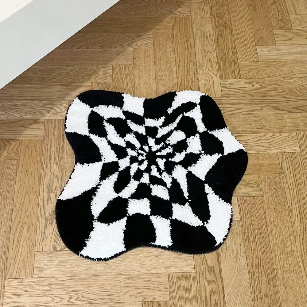 Tapis spiralé noir et blanc à velours texturé sur un sol en bois.