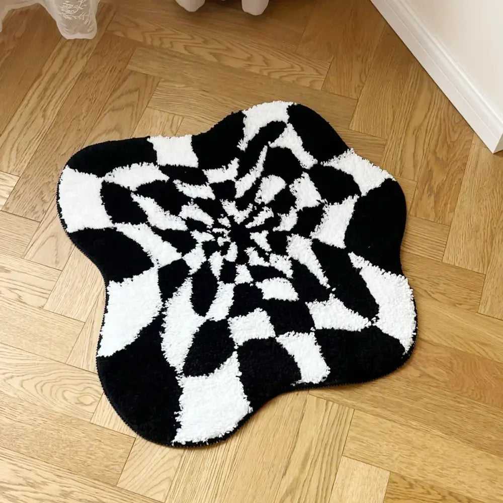 Tapis spiralé noir et blanc à velours texturé, probablement fabriqué en matériau moelleux.