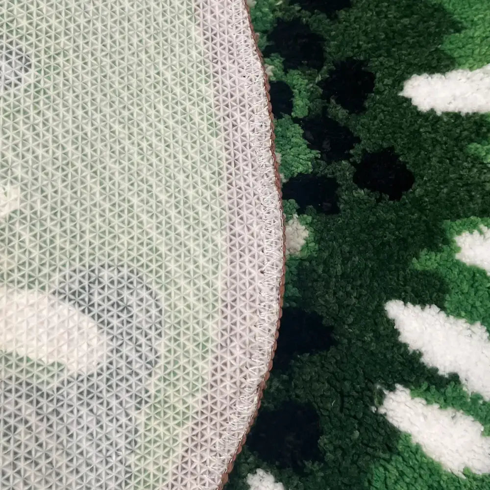Couverture à motif camouflage avec bordure rose et accents verts, blancs, noirs.