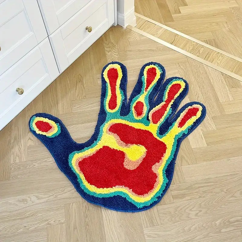 Tapis moelleux en forme de main vibrante avec une paume rouge audacieuse et des extrémités des doigts jaunes soulignées en turquoise sur un fond bleu profond.