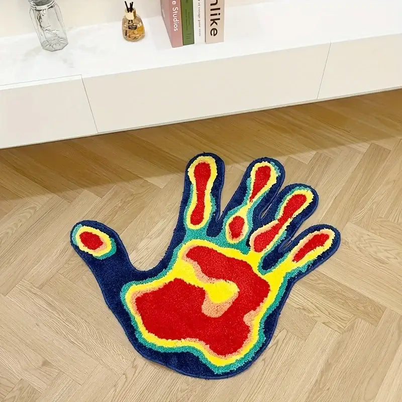 Tapis vibrant et moelleux en forme de main avec un dégradé de fils rouges, jaunes et bleus.