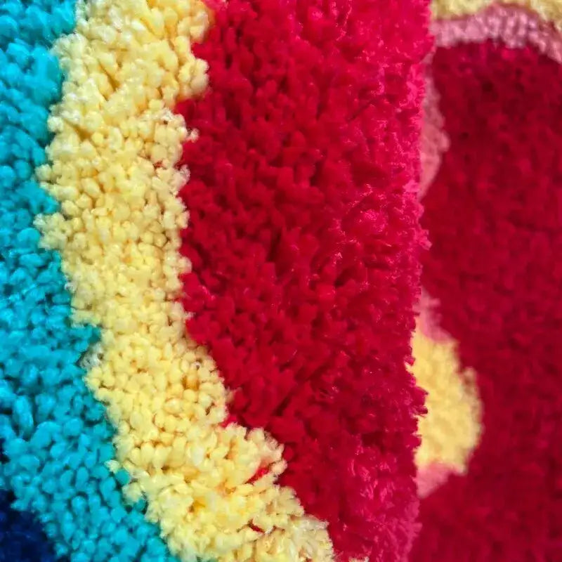 Tissu en peluche multicolore vibrant avec une surface douce et texturée en rayures audacieuses de turquoise, jaune et rouge.