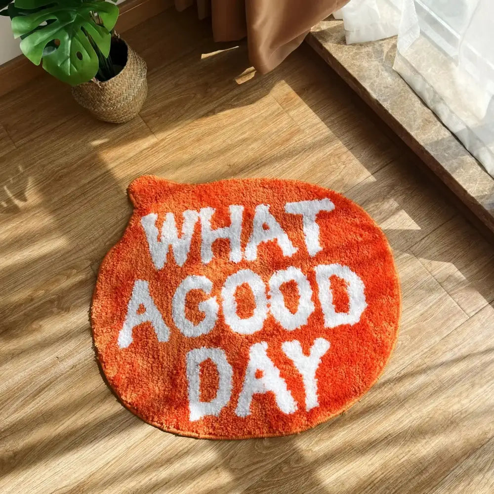 Tapis de bain orange moelleux avec texte brodé blanc indiquant « quelle belle journée »