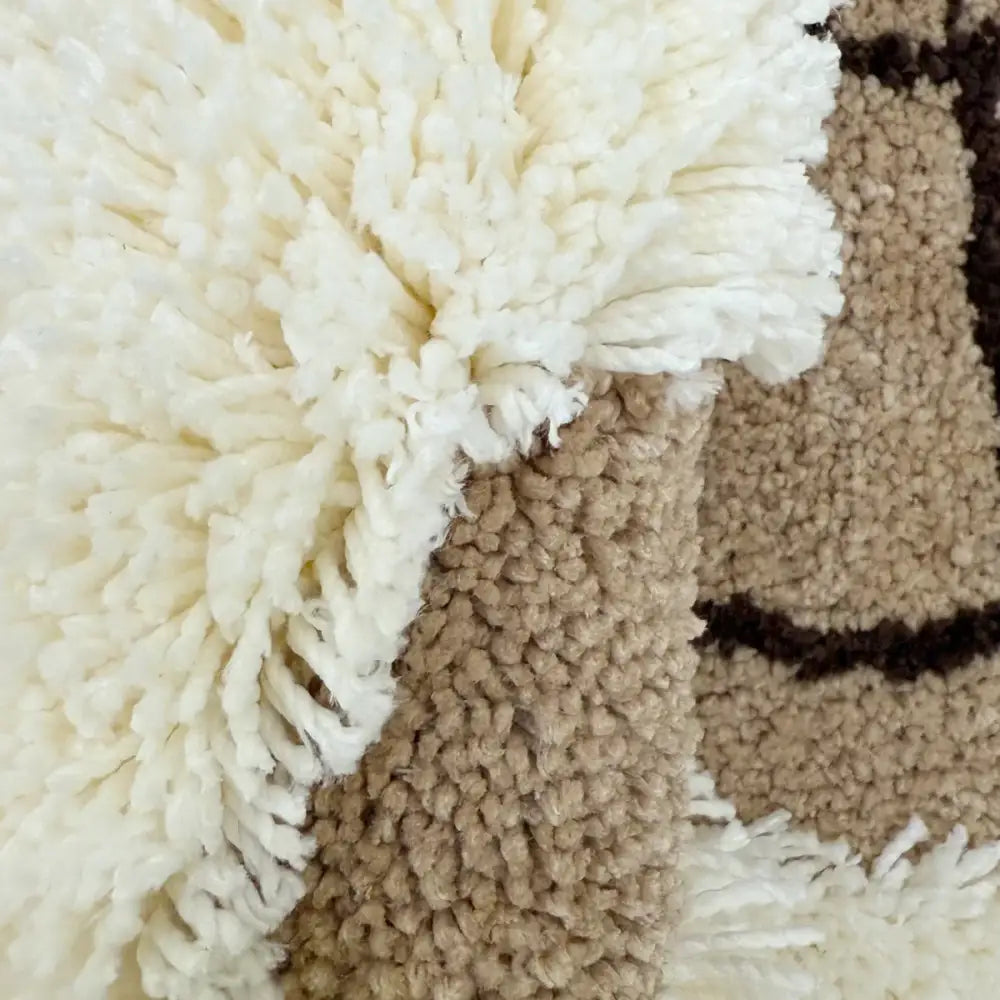 Tapis shaggy moelleux de couleur crème avec une surface texturée et duveteuse et des sections tissées contrastantes en marron.