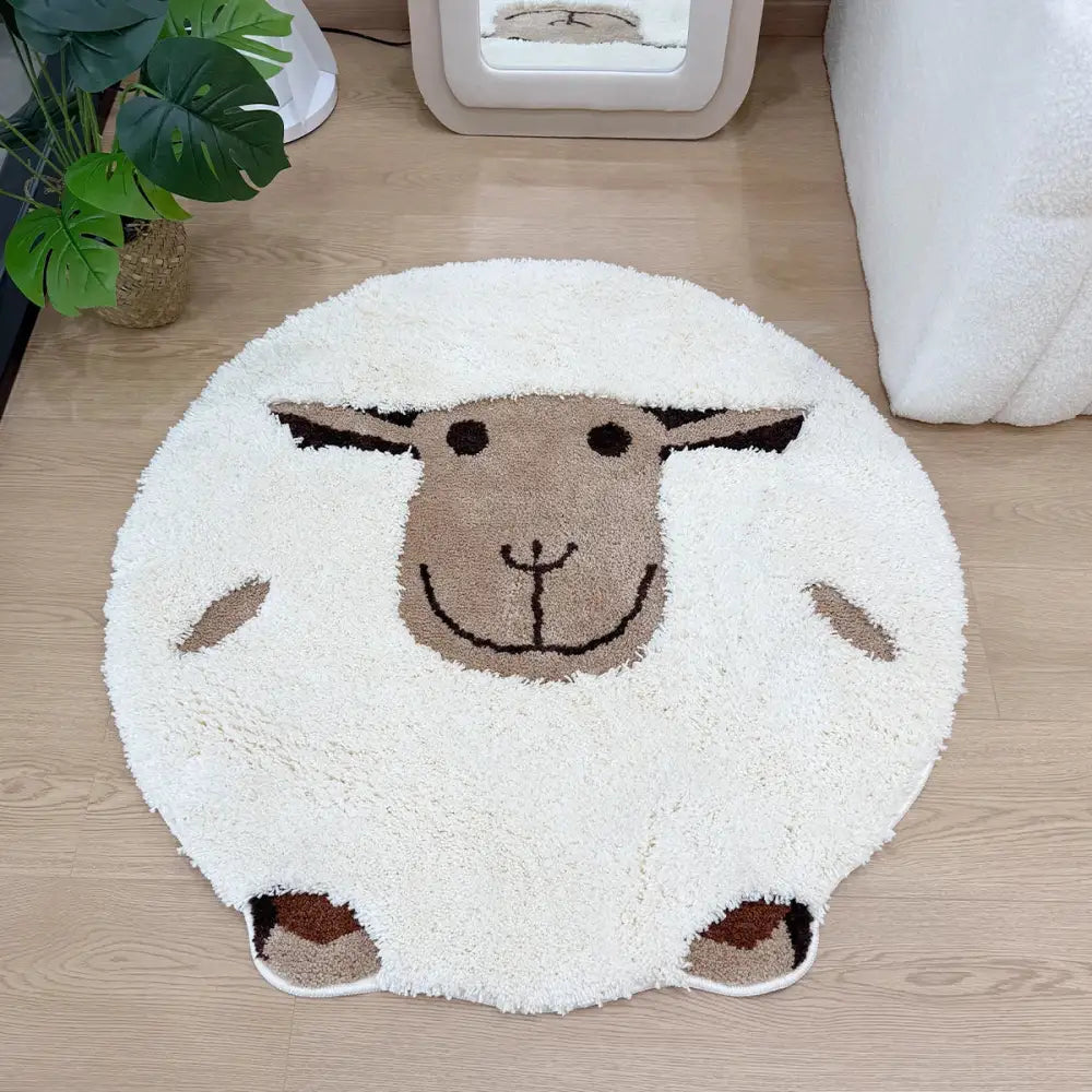 Un tapis de bain moelleux et rond en forme de mouton, avec un corps blanc duveteux et des détails de visage marron.