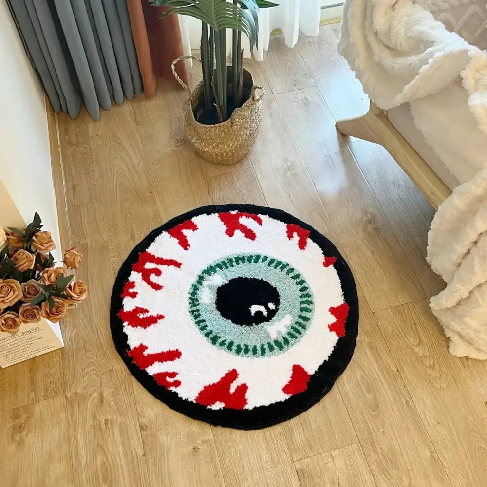 Tapis à thème œil rond avec des accents noir, blanc, rouge et vert sur un sol en bois.