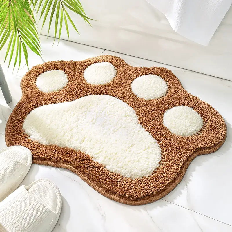 Tapis de bain avec empreintes de pattes marron et blanc en matériau à poils doux.